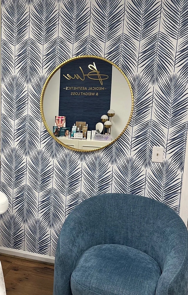 Spa interior with mirror and decorative wallpaper.