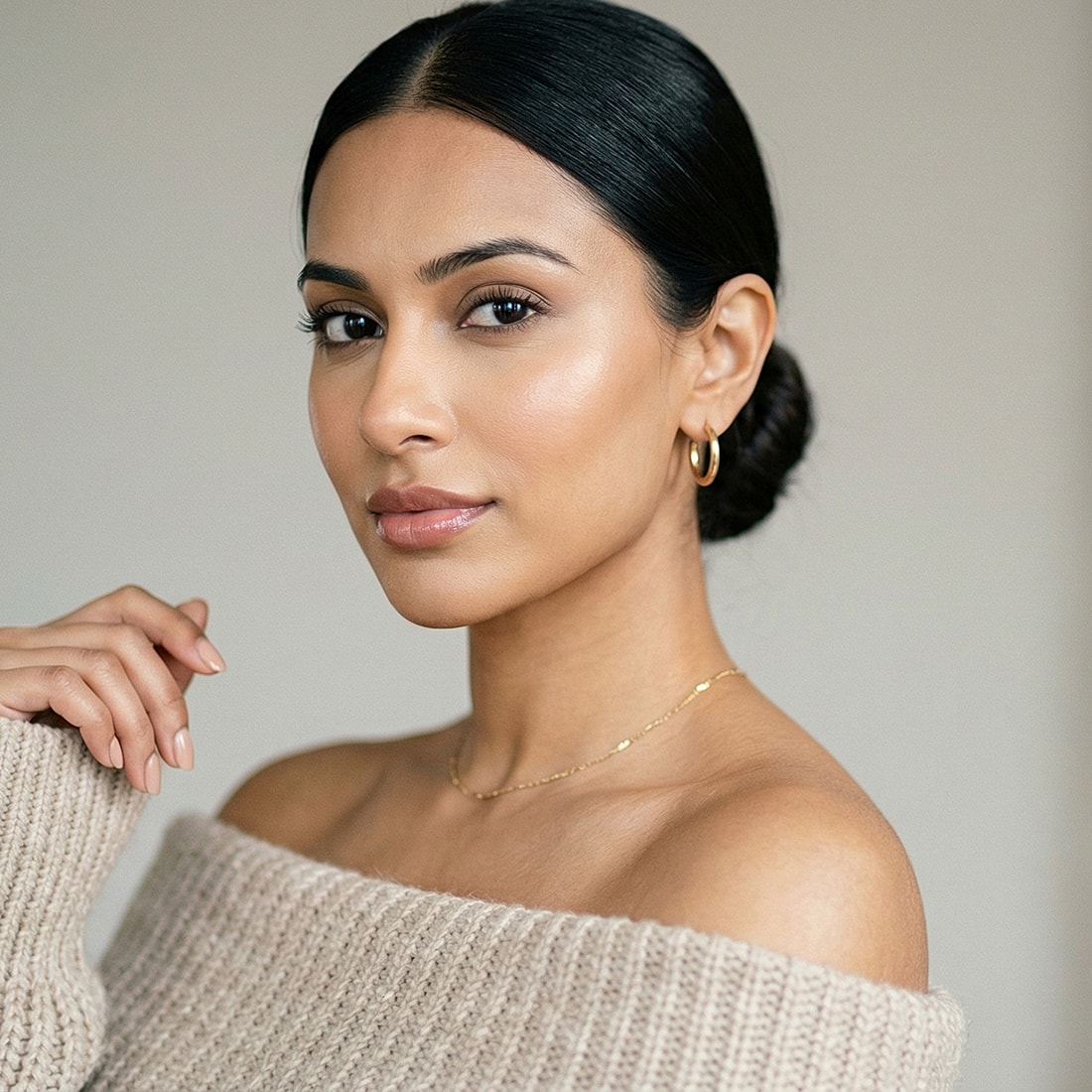 Woman with sleek hair in soft sweater.